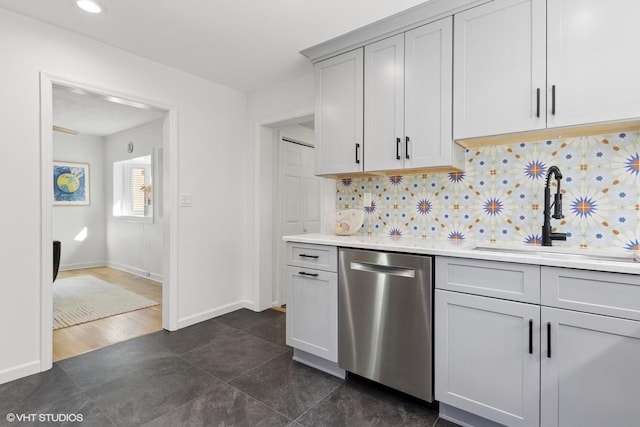 65 Union St, Beacon, NY 12508 - kitchen with stainless steel dishwasher, backsplash, light countertops, dark tile patterned floors, and gray cabinetry