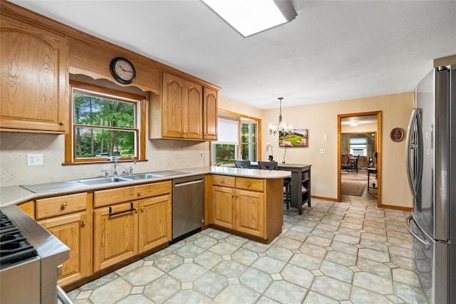 5 Linda Ct, Oyster Bay, NY 11771 - kitchen with stainless steel appliances, a peninsula, a chandelier, backsplash, and pendant lighting