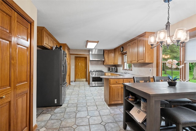 5 Linda Ct, Oyster Bay, NY 11771 - kitchen featuring stainless steel appliances, wall chimney exhaust hood, a chandelier, a peninsula, and light countertops