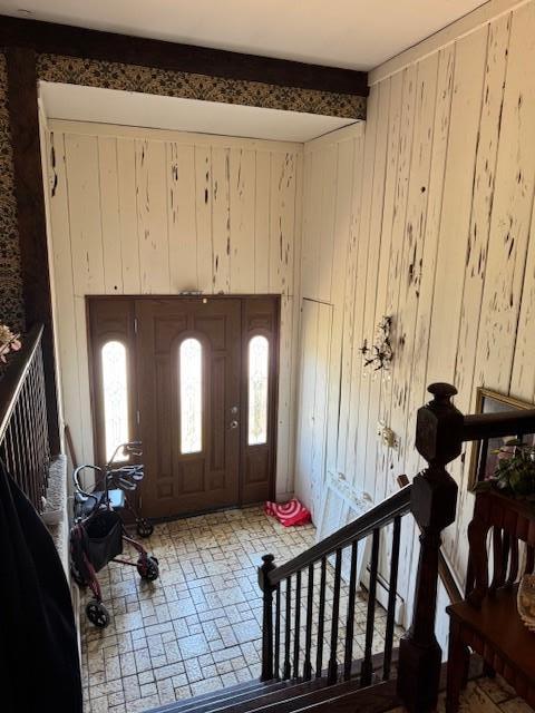 3214 Monterey Dr, Merrick, NY 11566 - foyer with wood walls, healthy amount of natural light, beam ceiling, and brick patterned floors