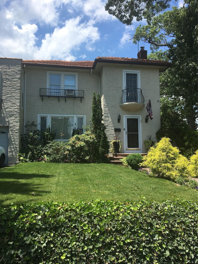 1484 164th St, Beechhurst, NY 11357 - rear view of house featuring a chimney, a lawn, a balcony, and a tile roof
