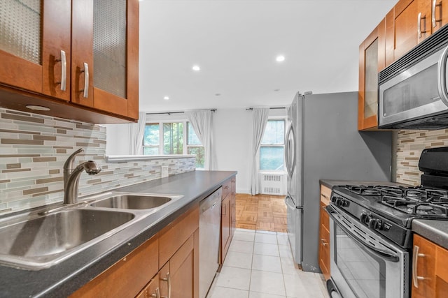 5425 Valles Ave Unit 1L, Bronx, NY 10471 - kitchen with appliances with stainless steel finishes, dark countertops, brown cabinetry, decorative backsplash, and recessed lighting