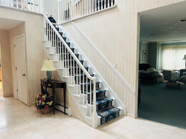 6 Cedarfield Ter, Setauket, NY 11780 - staircase featuring a baseboard radiator, a towering ceiling, ornamental molding, and tile patterned floors