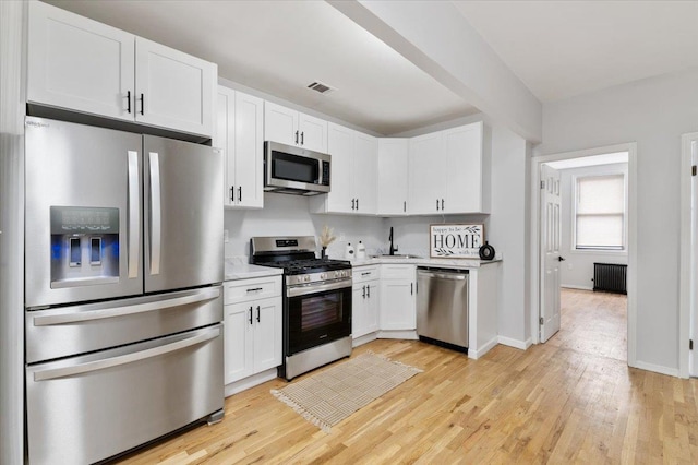 748 Georgia Ave, Brooklyn, NY 11207 - kitchen with appliances with stainless steel finishes, radiator, light countertops, and white cabinetry