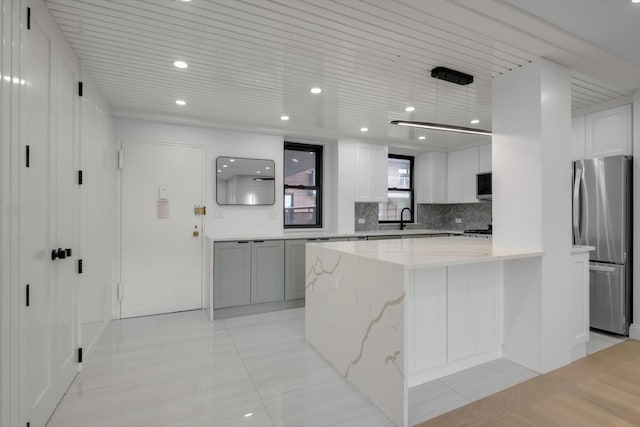4705 Henry Hudson Pkwy W Unit 6J, Bronx, NY 10471 - kitchen with stainless steel appliances, backsplash, light stone counters, white cabinets, and recessed lighting