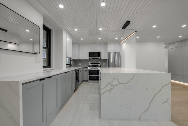 4705 Henry Hudson Pkwy W Unit 6J, Bronx, NY 10471 - kitchen featuring stainless steel appliances, recessed lighting, tasteful backsplash, a kitchen island, and light stone counters