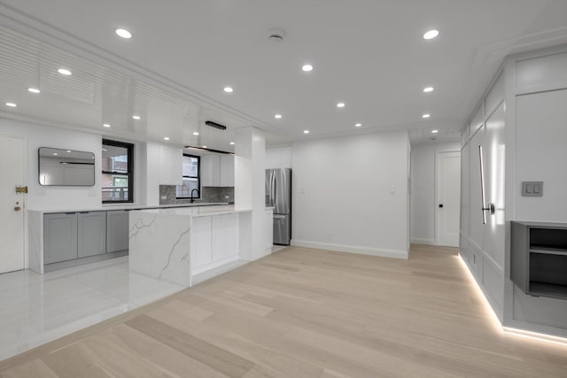 4705 Henry Hudson Pkwy W Unit 6J, Bronx, NY 10471 - kitchen featuring stainless steel fridge with ice dispenser, light wood finished floors, white cabinetry, heating unit, and backsplash