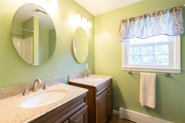 4 Pasture Ln, Poughkeepsie, NY 12603 - bathroom with two vanities, a baseboard heating unit, and wood finished floors