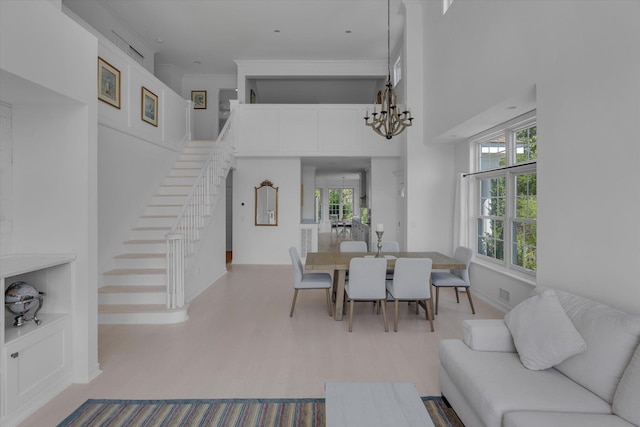 18 Tall Tree Cir, Jamesport, NY 11901 - dining room with stairs, a high ceiling, a chandelier, and wood finished floors