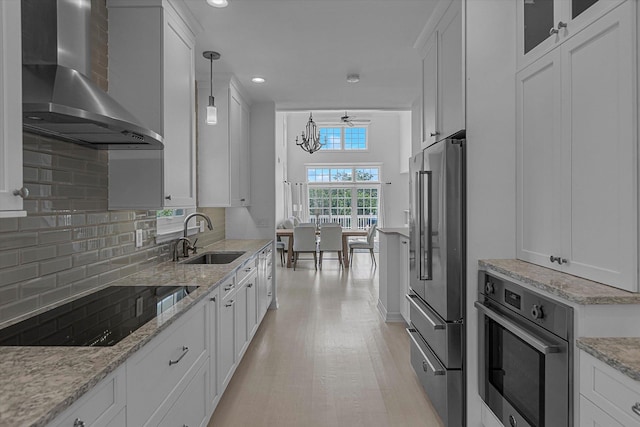 18 Tall Tree Cir, Jamesport, NY 11901 - kitchen with wall chimney range hood, stainless steel appliances, white cabinetry, tasteful backsplash, and recessed lighting