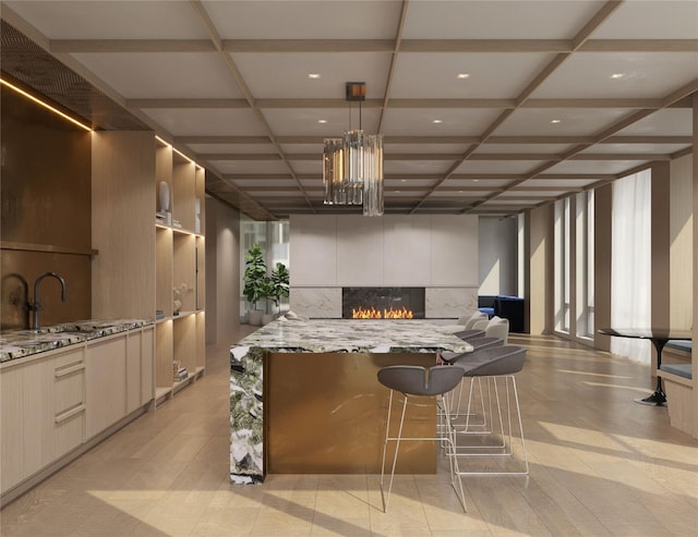 133-25 37th Ave Unit 6B, Flushing, NY 11354 - kitchen featuring a tile fireplace, modern cabinets, light stone countertops, a center island, and pendant lighting