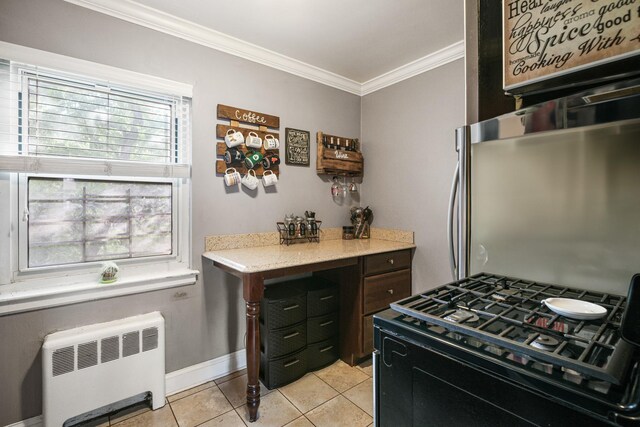 520 Tuckahoe Rd Unit 3B, Yonkers, NY 10710 - kitchen with black gas range oven, radiator heating unit, ornamental molding, light tile patterned flooring, and light stone countertops