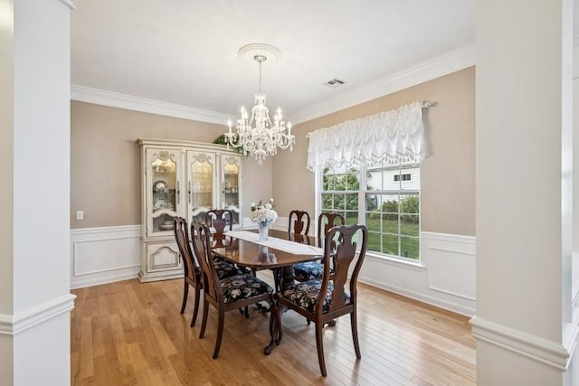 15 Louden Loop, Mount Sinai, NY 11766 - dining room featuring a chandelier, light wood-style flooring, a wainscoted wall, and crown molding