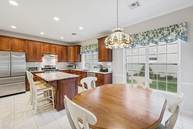 15 Louden Loop, Mount Sinai, NY 11766 - kitchen featuring high end refrigerator, range, under cabinet range hood, a center island, and light tile patterned floors