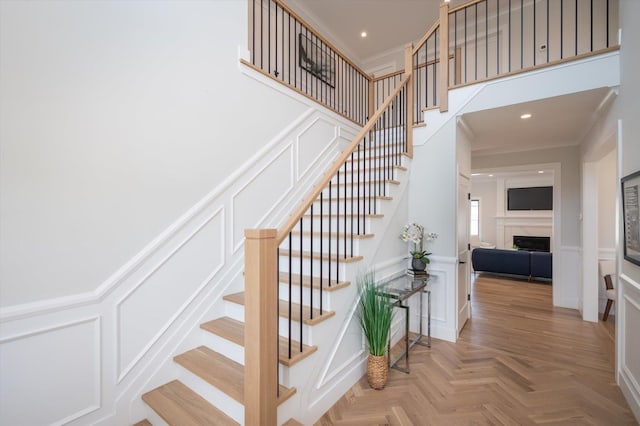 724 Pleasant Ave, Westbury, NY 11590 - staircase with a decorative wall, ornamental molding, a fireplace, recessed lighting, and a wainscoted wall