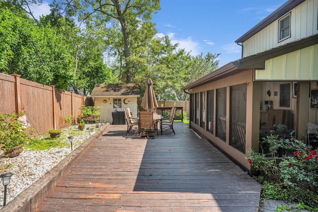 41 Tyler Ave, Sound Beach, NY 11789 - wooden deck with outdoor dining area, a fenced backyard, and a sunroom
