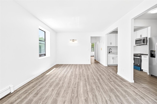 800 Brook Ave Unit 13B, Bronx, NY 10451 - unfurnished living room with a baseboard radiator and light wood-style flooring