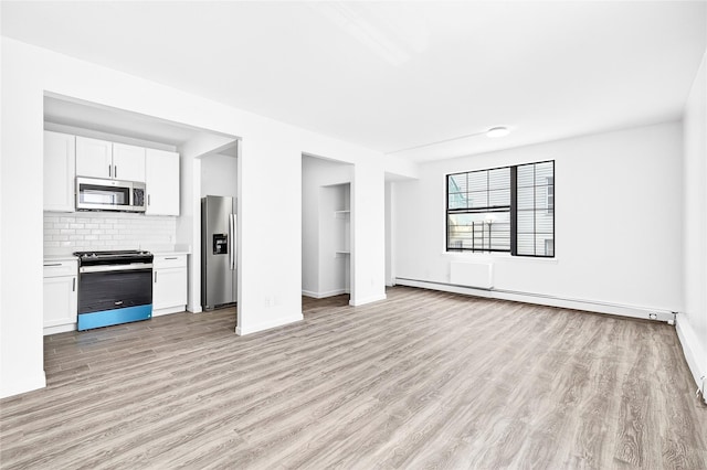 800 Brook Ave Unit 13B, Bronx, NY 10451 - unfurnished living room with a baseboard heating unit and light wood-style flooring