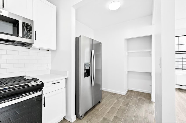 800 Brook Ave Unit 13B, Bronx, NY 10451 - kitchen featuring stainless steel appliances, backsplash, light countertops, and white cabinets