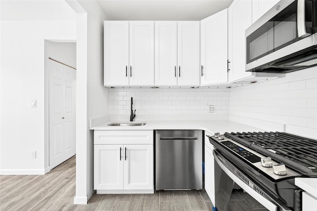800 Brook Ave Unit 13B, Bronx, NY 10451 - kitchen featuring appliances with stainless steel finishes, light countertops, light wood-type flooring, and white cabinetry