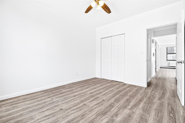 800 Brook Ave Unit 13B, Bronx, NY 10451 - unfurnished bedroom featuring wood finished floors, a closet, a ceiling fan, and baseboard heating