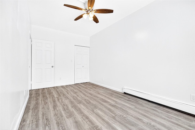 800 Brook Ave Unit 13B, Bronx, NY 10451 - unfurnished bedroom with a baseboard heating unit, wood finished floors, a closet, and a ceiling fan