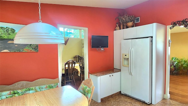 27 Maiden Ln, New City, NY 10956 - kitchen featuring white refrigerator with ice dispenser, white cabinetry, and decorative light fixtures