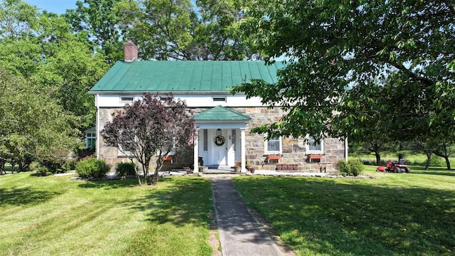 321 Crans Mill Rd, Pine Bush, NY 12566 - neoclassical home featuring a standing seam roof, a front lawn, stone siding, a chimney, and a metal roof