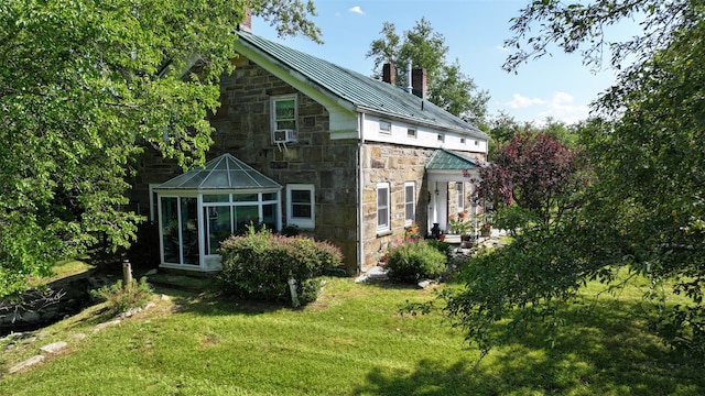 321 Crans Mill Rd, Pine Bush, NY 12566 - back of property featuring a chimney, stone siding, a standing seam roof, a lawn, and a sunroom