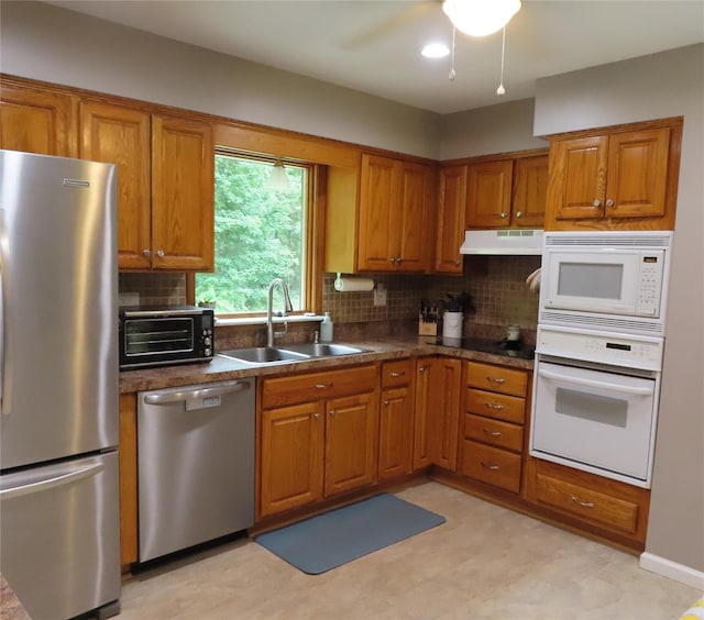4 St Michaels Ln, Walden, NY 12586 - kitchen featuring stainless steel appliances, brown cabinets, tasteful backsplash, under cabinet range hood, and dark countertops