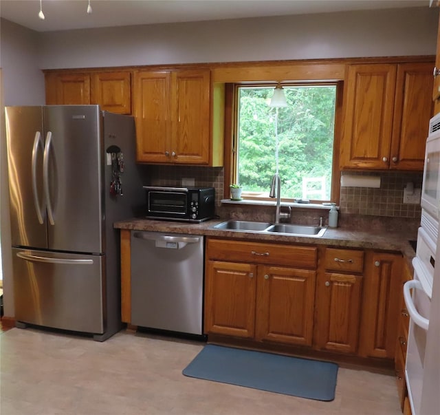 4 St Michaels Ln, Walden, NY 12586 - kitchen featuring stainless steel appliances, brown cabinets, dark countertops, and decorative backsplash