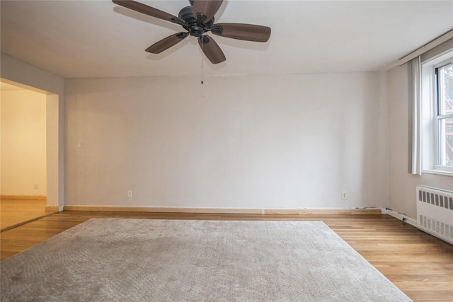 4 Sadore Ln Unit 3E, Yonkers, NY 10710 - empty room with radiator, light wood-style flooring, and ceiling fan