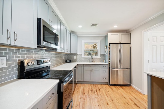 1126 Park Blvd, Massapequa Park, NY 11762 - kitchen featuring stainless steel appliances, light wood-type flooring, light countertops, ornamental molding, and decorative backsplash