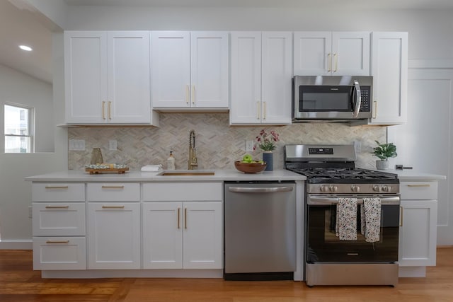 14 Staples St, Kingston, NY 12401 - kitchen with stainless steel appliances, white cabinets, light countertops, backsplash, and recessed lighting