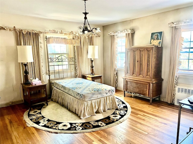 41 Derby Ave, Cedarhurst, NY 11516 - bedroom featuring a chandelier, wood finished floors, and radiator