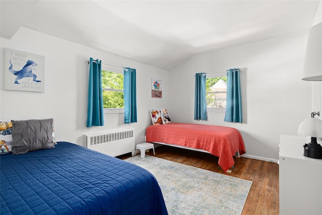 7 Garnet Ln, Plainview, NY 11803 - bedroom with radiator, multiple windows, vaulted ceiling, and hardwood / wood-style flooring
