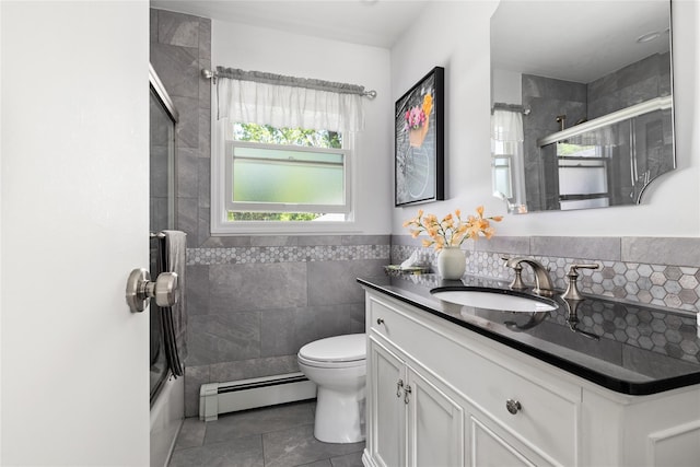 7 Garnet Ln, Plainview, NY 11803 - bathroom with a baseboard heating unit, tile patterned flooring, vanity, tile walls, and combined bath / shower with glass door