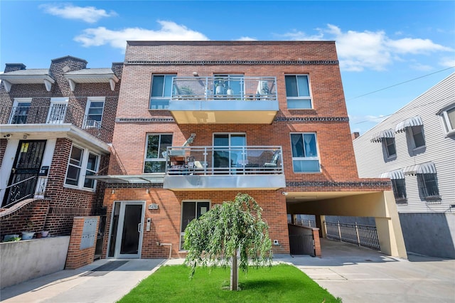 7425 43rd Ave Unit 2A, Elmhurst, NY 11373 - view of front of house featuring brick siding, a balcony, and concrete driveway