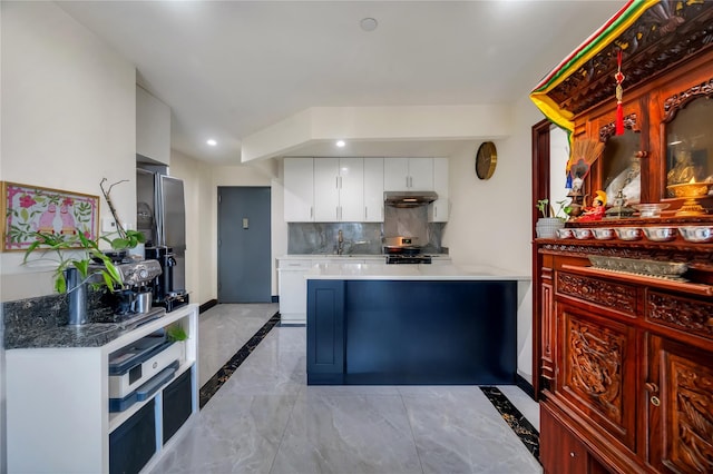 7425 43rd Ave Unit 2A, Elmhurst, NY 11373 - kitchen featuring white cabinetry, tasteful backsplash, light marble finish flooring, under cabinet range hood, and inlaid floor details