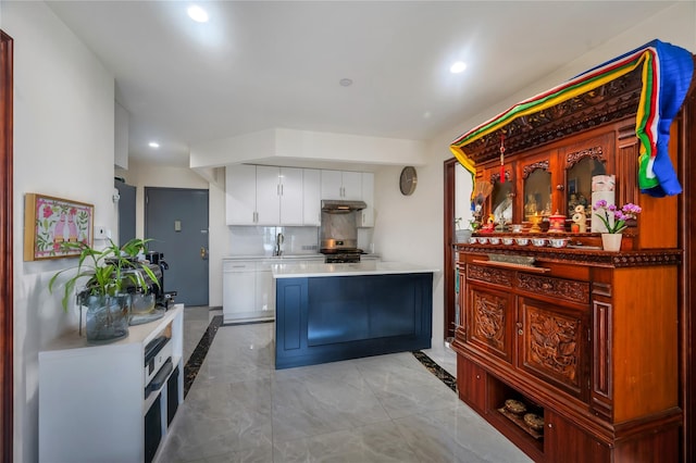 7425 43rd Ave Unit 2A, Elmhurst, NY 11373 - kitchen featuring white cabinetry, light marble finish floors, under cabinet range hood, recessed lighting, and decorative backsplash