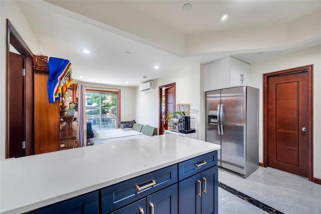 7425 43rd Ave Unit 2A, Elmhurst, NY 11373 - kitchen with stainless steel fridge with ice dispenser, a wall unit AC, blue cabinets, light countertops, and inlaid floor details