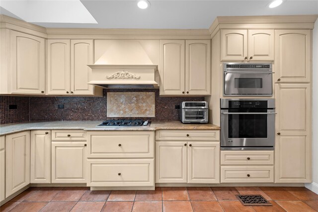 156 Lefferts Rd, Woodmere, NY 11598 - kitchen with appliances with stainless steel finishes, custom range hood, cream cabinetry, light countertops, and backsplash