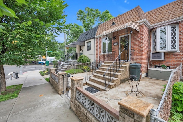 6303 74th St, Middle Village, NY 11379 - view of front of property featuring brick siding, roof with shingles, and mansard roof
