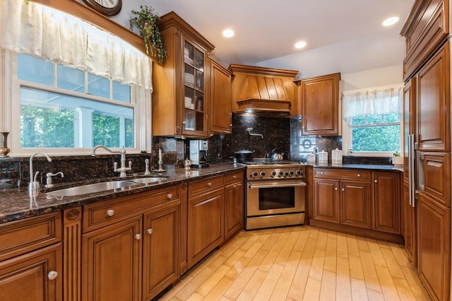 107 S Country Rd, East Patchogue, NY 11772 - kitchen featuring high end appliances, custom range hood, healthy amount of natural light, brown cabinetry, and recessed lighting