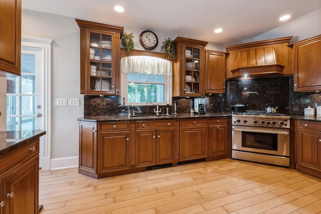 107 S Country Rd, East Patchogue, NY 11772 - kitchen featuring stainless steel range, light wood-type flooring, dark stone countertops, brown cabinets, and recessed lighting