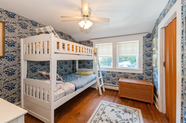 107 S Country Rd, East Patchogue, NY 11772 - bedroom with wood finished floors, wallpapered walls, a baseboard heating unit, and a ceiling fan