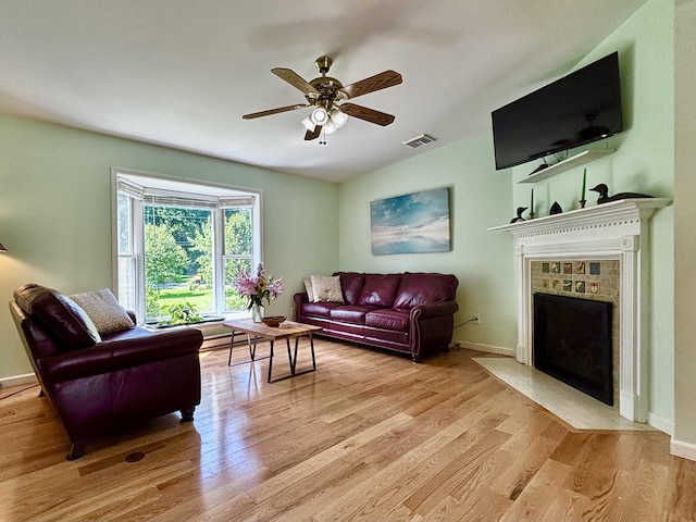 167 Benner Rd, Red Hook, NY 12571 - living area with light wood-style flooring, a tiled fireplace, and ceiling fan