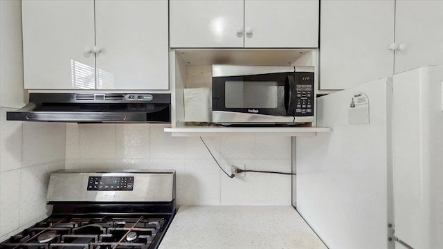 144-37 79th Ave Unit 1R, Kew Garden Hills, NY 11367 - kitchen featuring stainless steel appliances, under cabinet range hood, white cabinetry, light countertops, and decorative backsplash