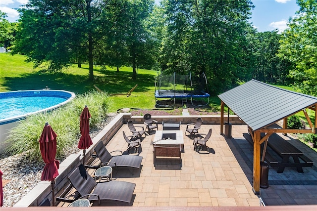 10 Von Trapp Ct, Washingtonville, NY 10992 - view of patio with a trampoline, a fire pit, an outdoor pool, and view of scattered trees