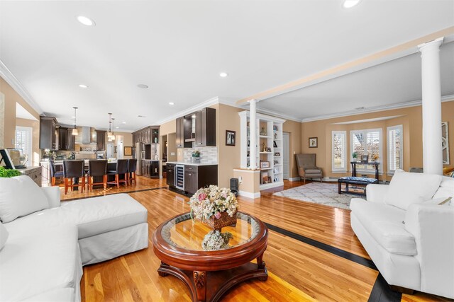 10 Von Trapp Ct, Washingtonville, NY 10992 - living area featuring ornate columns, crown molding, light wood-type flooring, wine cooler, and recessed lighting